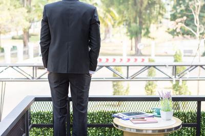 Rear view of a man standing on table