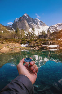 Man with a compass in his hand in high mountains near a clean lake. travel concept. landscape