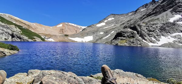 Scenic view of lake and mountains against blue sky