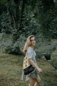 Full length of woman standing in forest