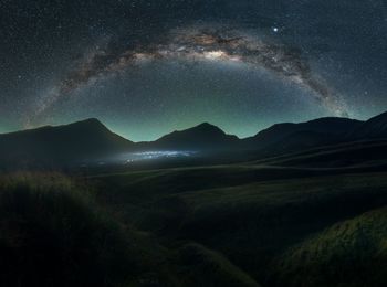 Scenic view of mountains against sky at night