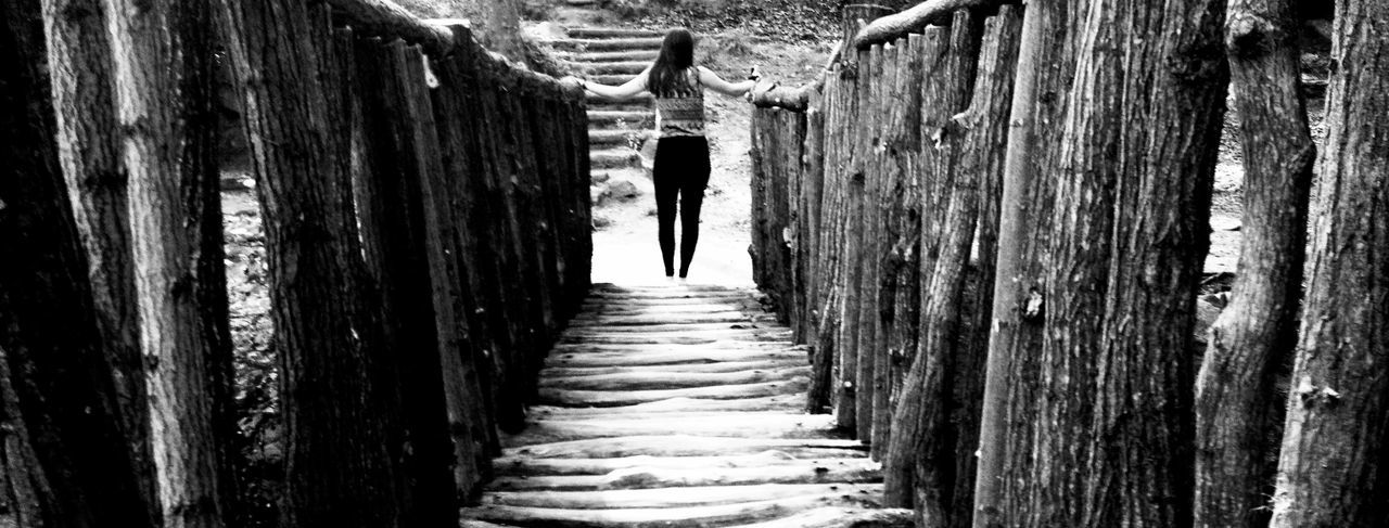 rear view, full length, the way forward, lifestyles, walking, wood - material, leisure activity, men, built structure, standing, wooden, architecture, person, diminishing perspective, day, boardwalk, outdoors