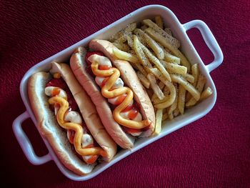 Close-up of hot dogs in bowl on table