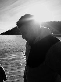 Side view of man in lake against sky