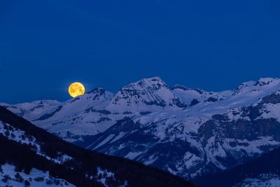 Scenic view of snowcapped mountains against sky at night