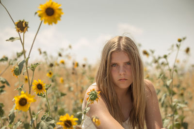 Portrait of woman at flower field on sunny day