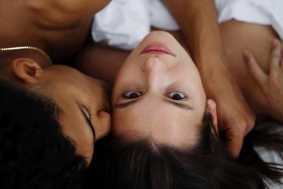 Close-up of young couple lying in bed