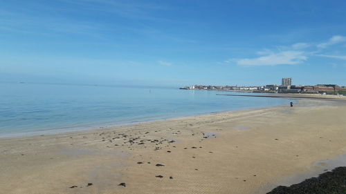 Scenic view of beach against blue sky