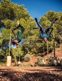 Full length of couple hanging on rod