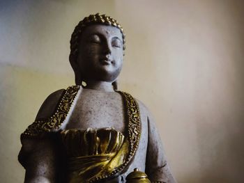 Statue of buddha against wall