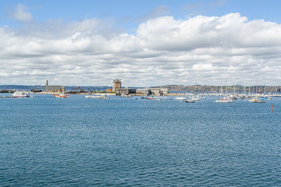 Sailboats by sea against sky in city