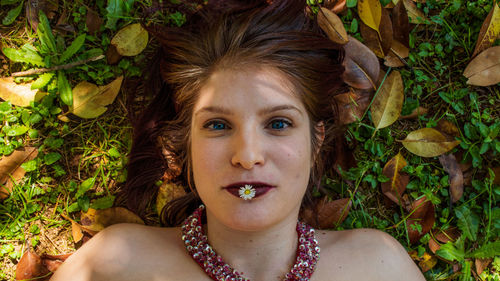 Portrait of young woman lying down outdoors