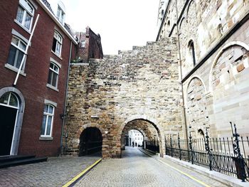 Footpath leading towards old town against sky