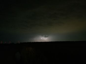 Silhouette landscape against sky at night