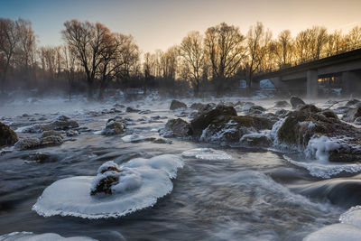 Scenic view of frozen river against sky during winter