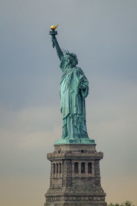 Low angle view of statue of liberty against sky