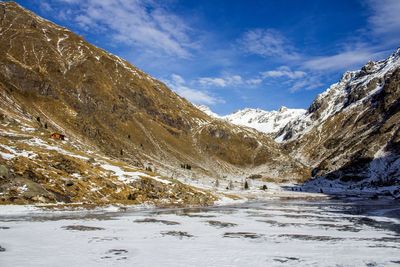 Snow covered landscape against rocky mountains