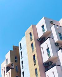 Low angle view of buildings against clear blue sky