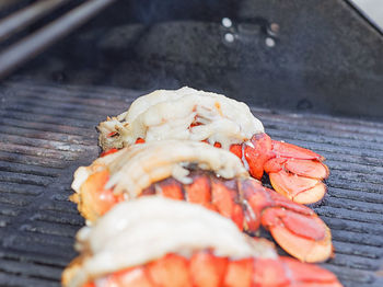 High angle view of lobster tail cooking on barbecue grill