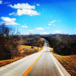 Road amidst trees against sky