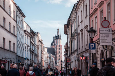 People walking on street amidst buildings in city