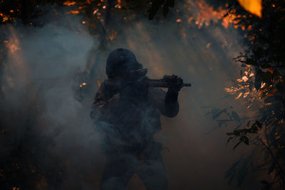 Men shooting with rifle at forest