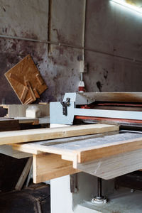 Carpenter working automated sanding machine for wood boards.