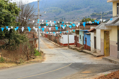 Flags hanging over road by houses