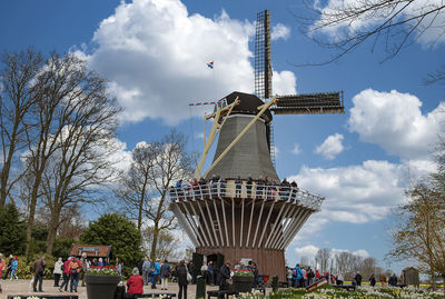 Group of people in traditional windmill against sky