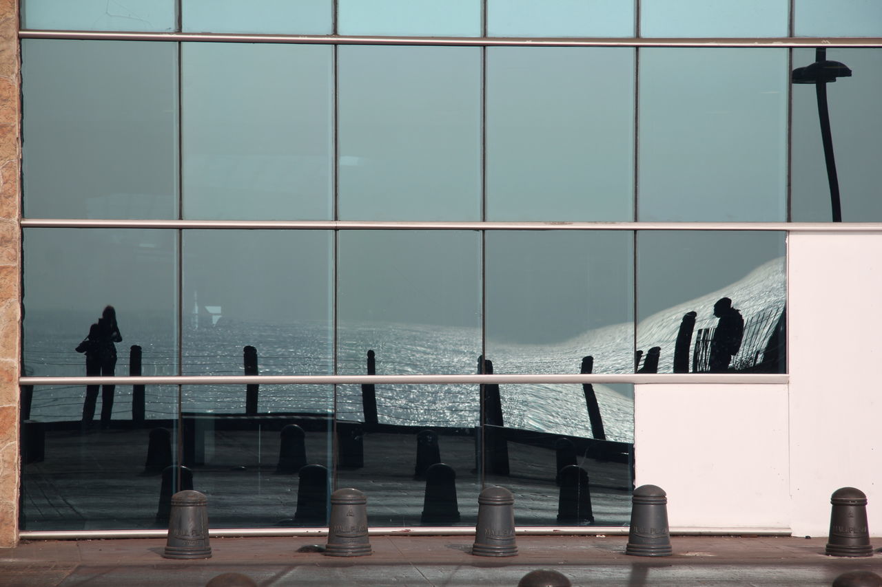 PEOPLE BY SEA AGAINST SKY SEEN THROUGH WINDOW