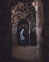 Rear view of man walking by arch in building