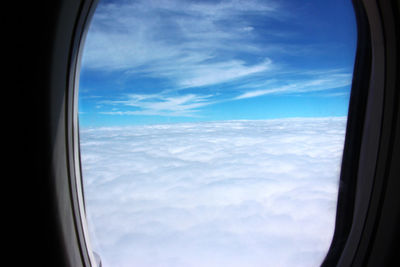 View of cloudy sky seen through airplane window