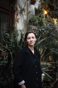 Portrait of woman standing against plants