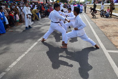 Men practicing karate on road during festival