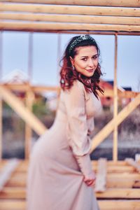 Portrait of woman wearing dress while standing at construction site