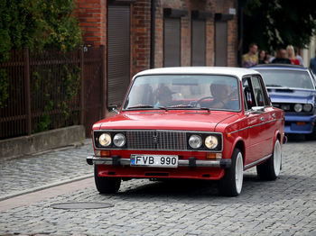 Red vintage car on street in city