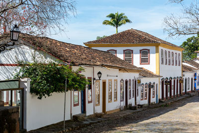 Houses by street in town against sky