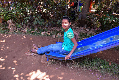 Portrait of smiling girl sitting on slide outdoors