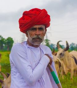 Portrait of man with horses standing on field against sky