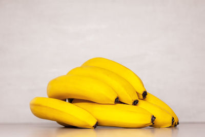 A bunch of yellow ripe bananas on a grey background close-up