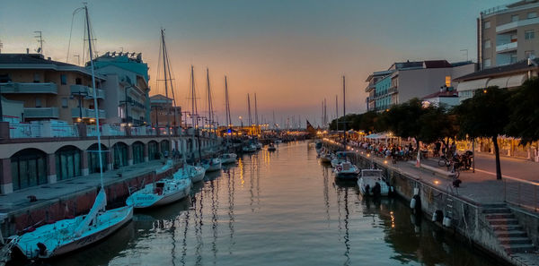 Boats moored at harbor during sunset