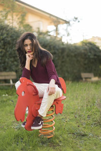 Beautiful thoughtful woman sitting on horse spring ride in back yard