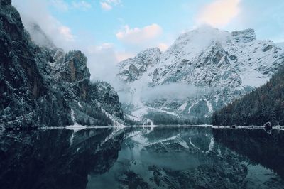 Snowcapped mountains reflecting on calm lake