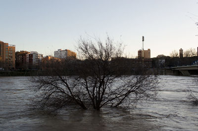 Scenic view of river against sky in city
