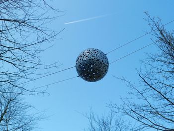 Low angle view of bare trees against blue sky