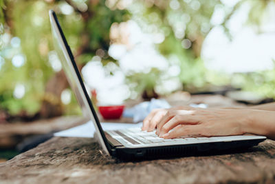 Cropped hands of man using laptop on table