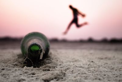 Close-up of person on beach against sky