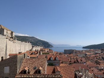 Town by sea against clear blue sky