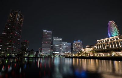 Illuminated urban skyline against sky at night