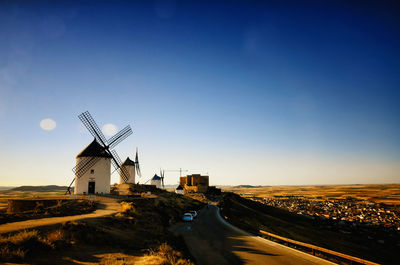 Traditional windmill on land against sky